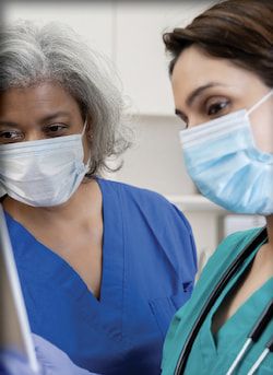 Two nurses wearing masks.