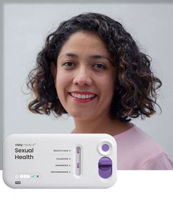 Smiling patient with Visby Medical Sexual Health device showing results.